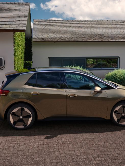 Seitenansicht des VW ID.3 in Olivgrün/Braun vor einem Haus