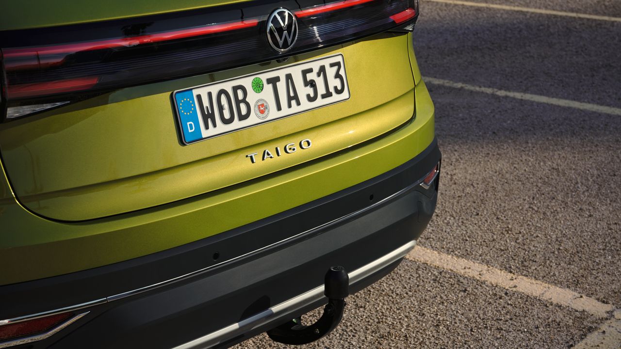 Detailansicht der optionalen Anhängerkupplung am Heck eines grünen VW Taigo