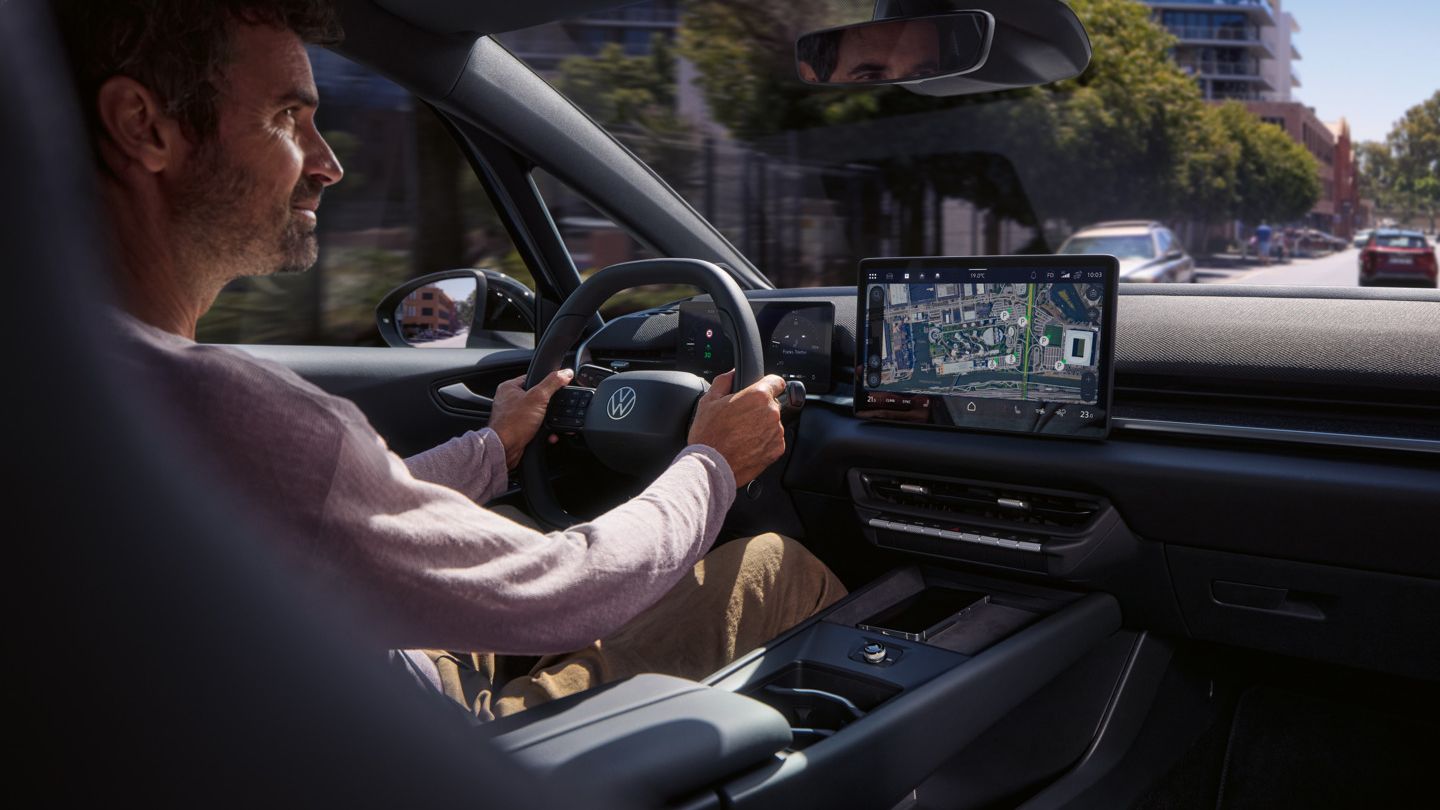 Ein Mann fährt einen VW ID.3 Neo, geleitet von der Online- Navigation auf dem Center-Display