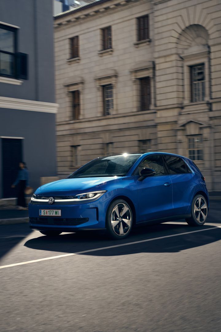 Ein blauer VW ID. Polo Style fährt durch eine Stadt.