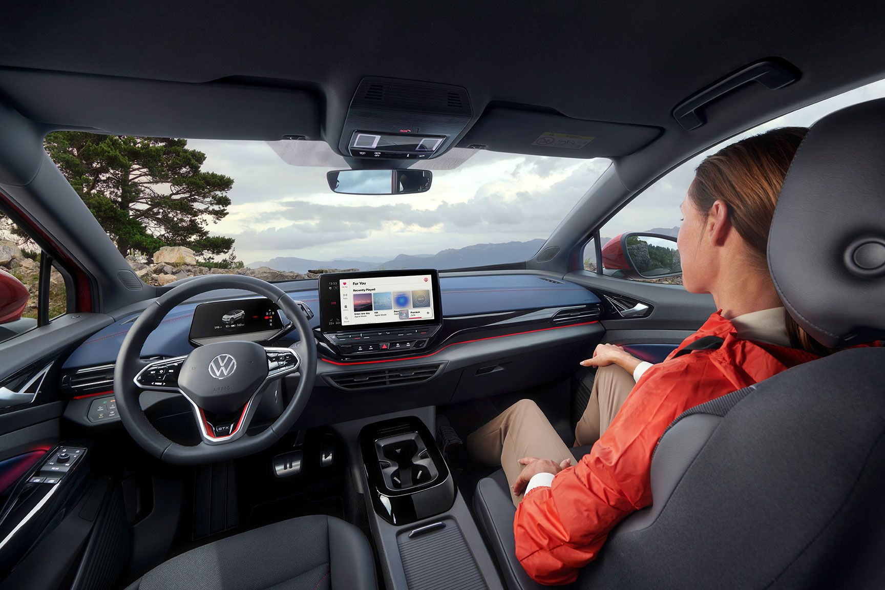 VW ID.5 GTX von innen. Blick auf Armaturen, Lenkrad, Sitze und Pedale. Eine junge Frau sitzt auf dem Beifahrersitz.